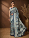 Dark grey printed saree in an all-over paisley and floral vine print with teal and mustard accents and a narrow grey border.
