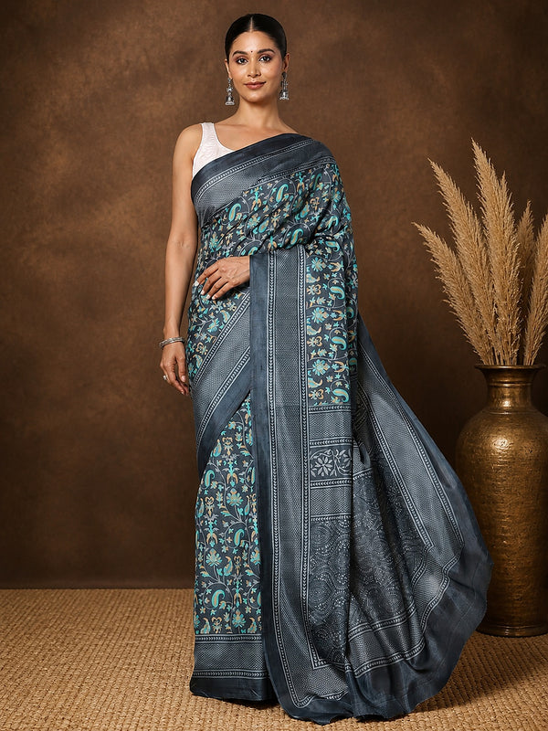 Charcoal grey printed saree with teal and gold botanical motifs and a large paisley medallion pallu.