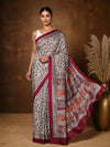 Off white Kashmiri Silk printed saree with a dense paisley and floral print in maroon and orange, a wide banded pallu and a medium maroon border.