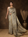 Muted olive printed saree in a small floral and paisley print with beige and cream, opening into a wide paisley end-panel at the pallu.