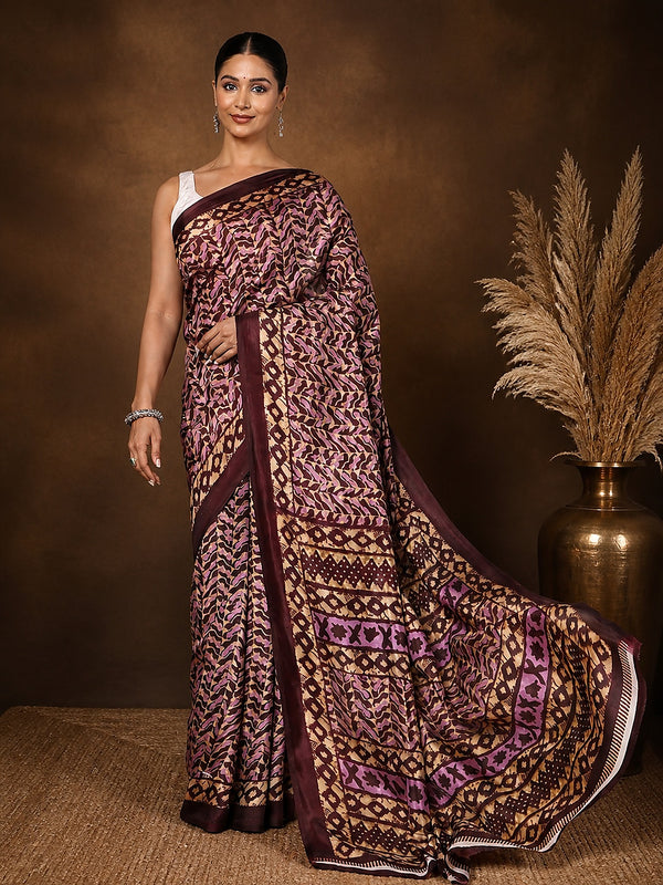 Dark brown and tan abstract geometric printed saree with a mauve accent and narrow brown border, styled with a reference blouse.